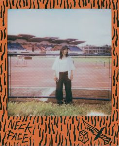Young woman stands near a stadium track.